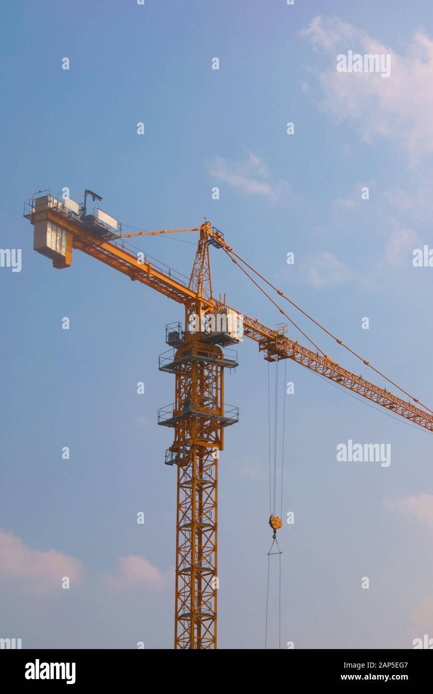 Turmkran in gelber Bauweise gegen einen klaren blauen Himmel. Aufnahmen mit niedrigem Winkel. Stockfoto