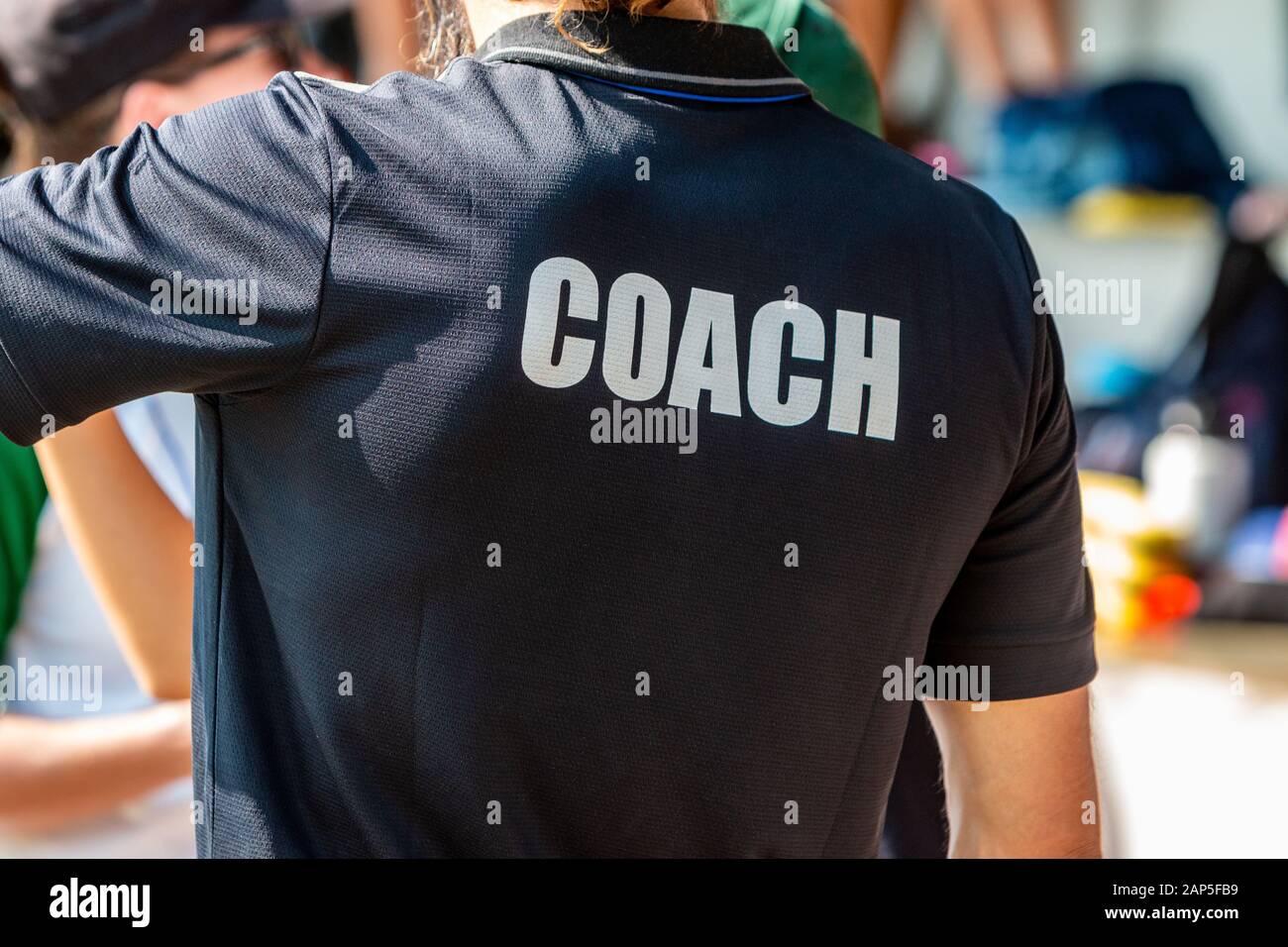 Rückansicht eines männlichen TRAINER TRAINER T-Shirt in schwarz Stockfoto