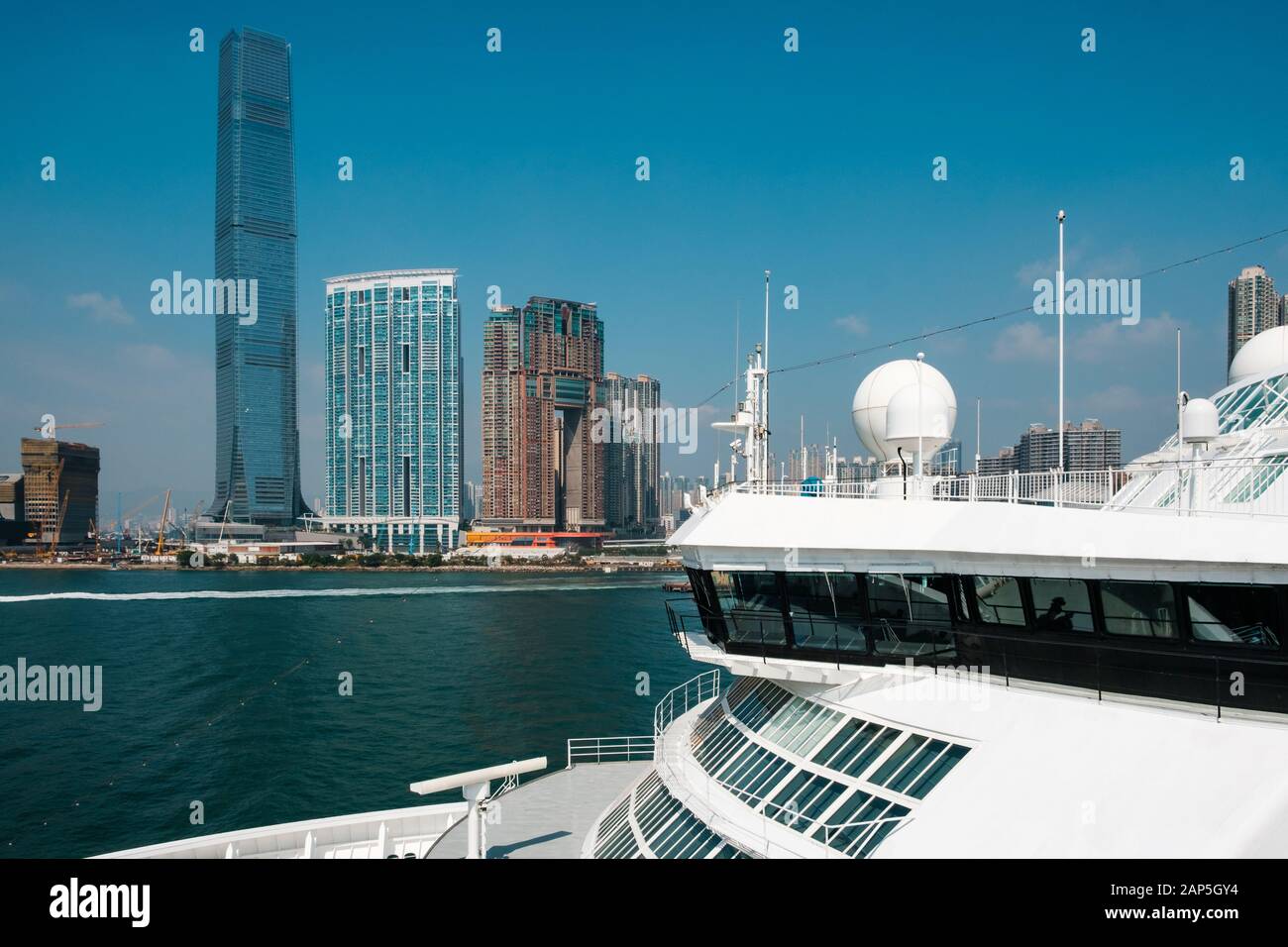 HongKong, Hongkong - November, 2019: Kreuzfahrtschiff und HongKong Skyline der Wolkenkratzer an der Hong Kong Cruise Terminal, Kowloon Stockfoto