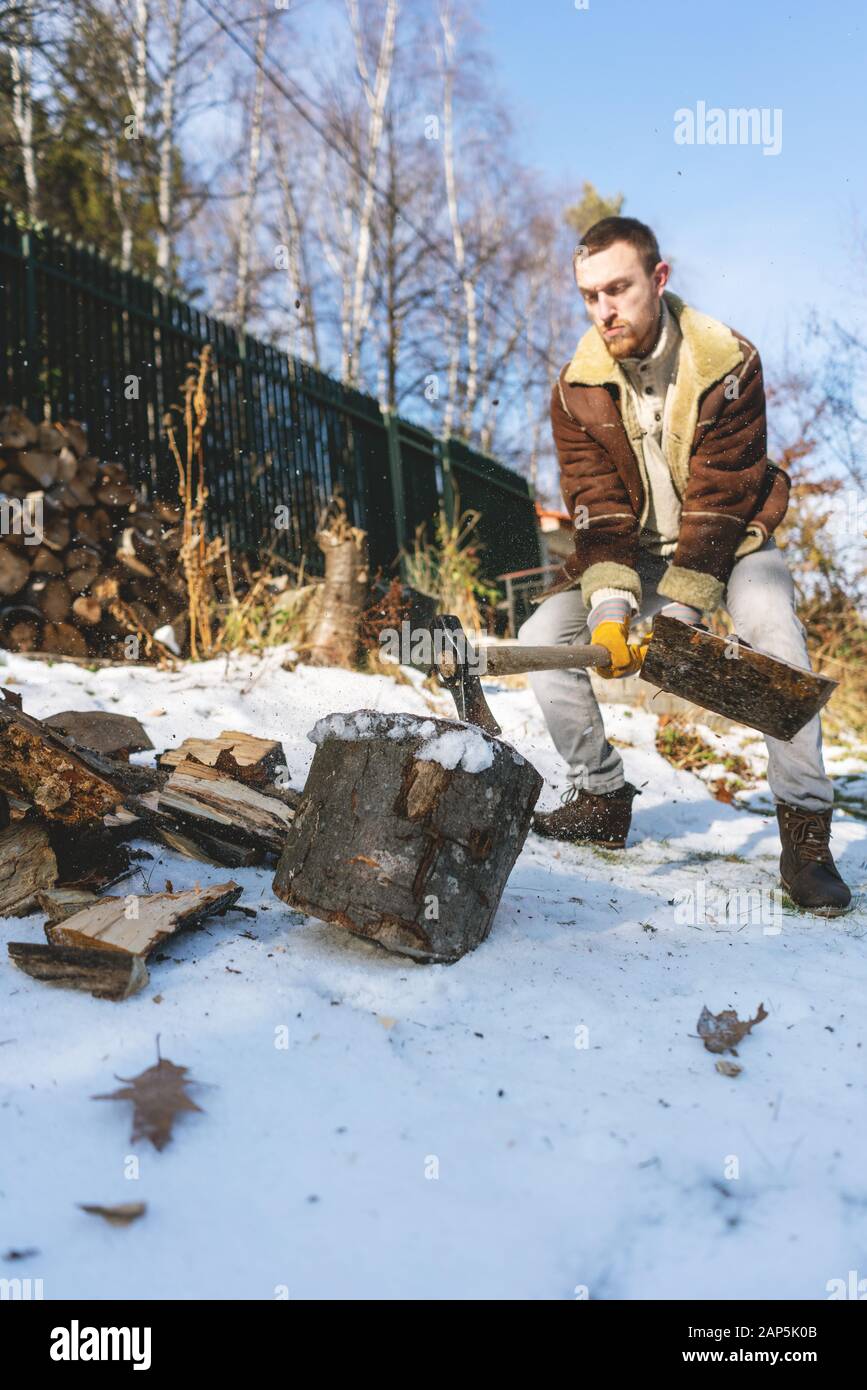 Man Holzhacken mit einer Axt, Stücke und Rückstände um Fliegen Stockfoto