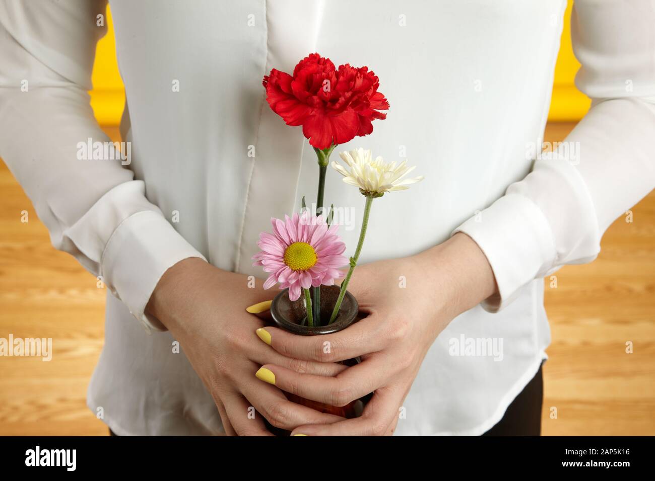 Hand mit Vase aus Blumen Stockfoto