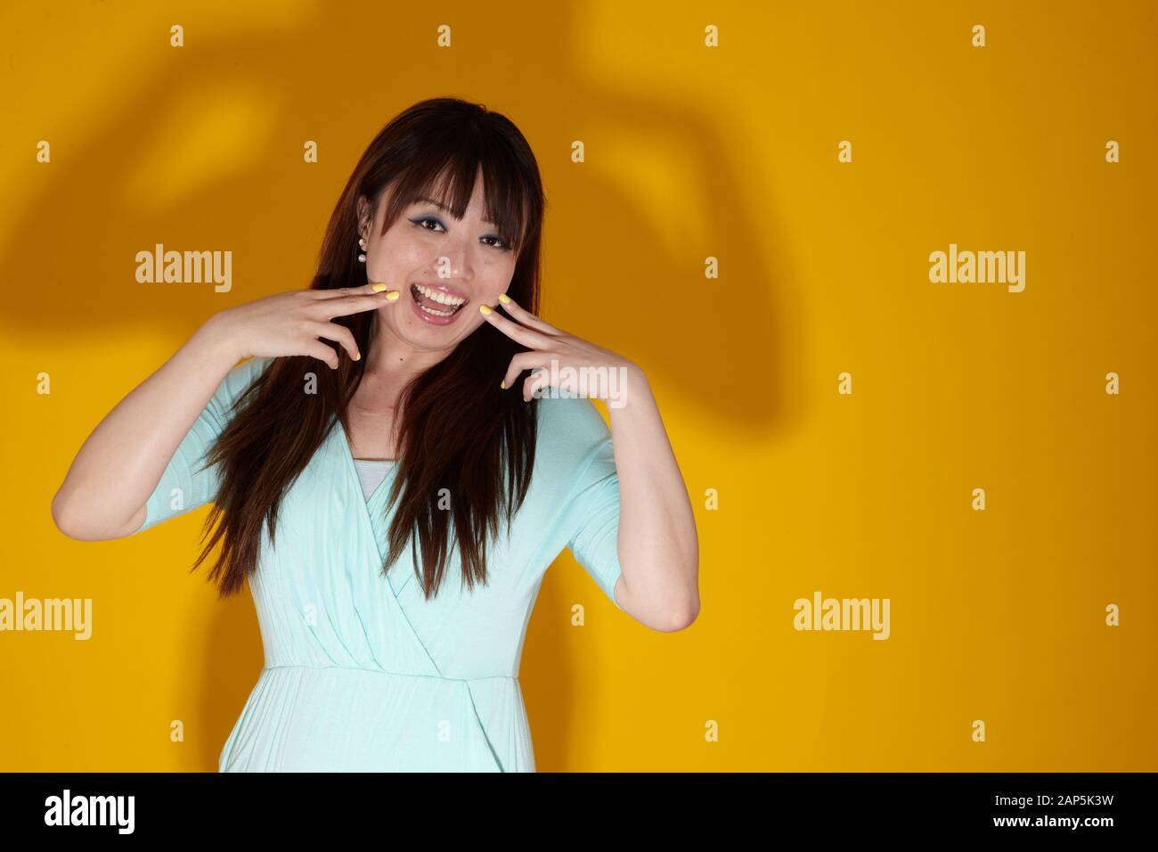 Fun Porträt von asiatischen weiblich auf gelbem Hintergrund Stockfoto