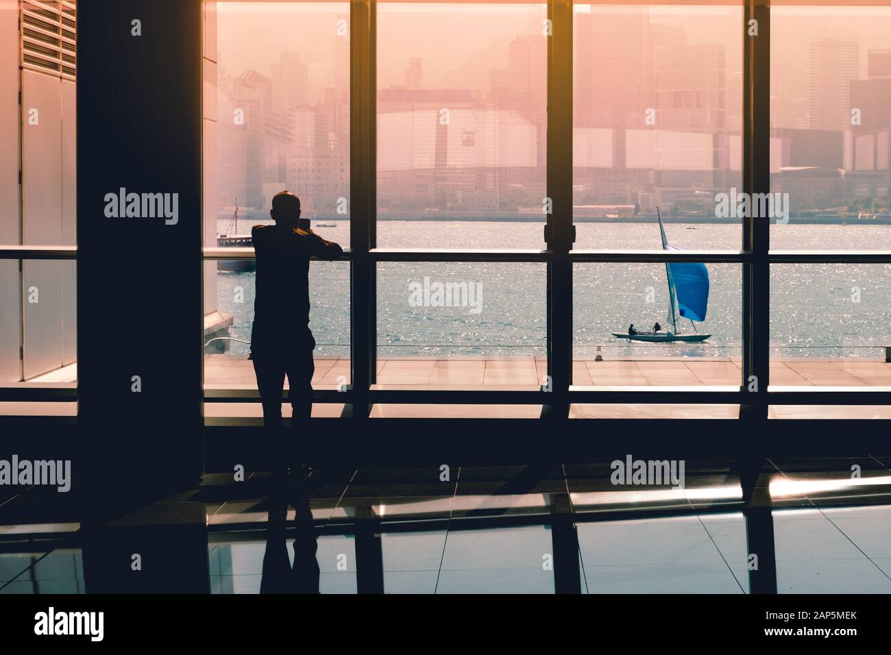 Person suchen auf Handy im Büro Fenster mit Segelboot im Hintergrund - Stockfoto