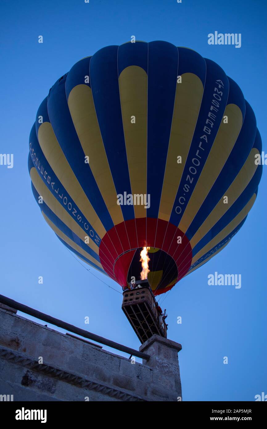 Kappadokien, Türkei, Europa: Heißluftballon im Morgengrauen über einer Terrasse in der Altstadt von Cavusin, in der historischen Region in Zentralanatolien Stockfoto