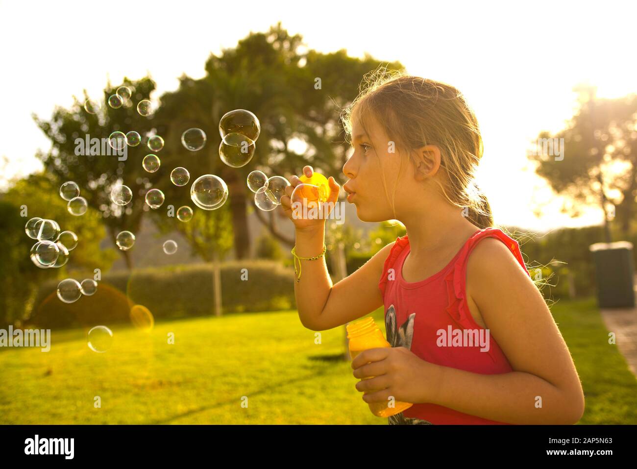 Junges Mädchen bläst Seifenblasen Stockfoto