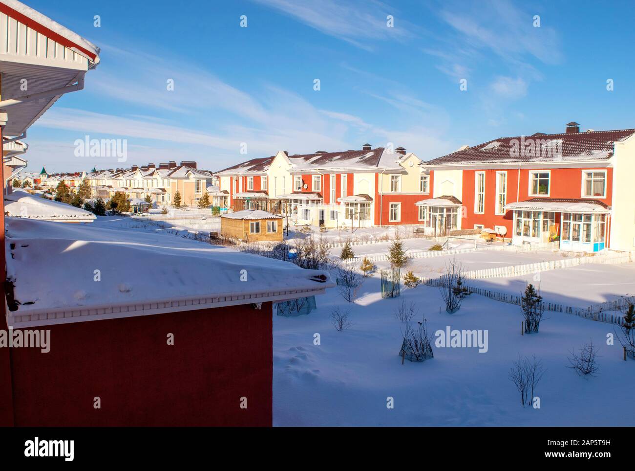 Roh von schönen bunten Häusern im Familiendorf im Winter auf blauem, klarem Himmel Hintergrund. Winter's Tale. Stockfoto
