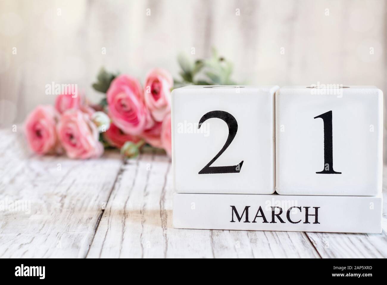Weißes Holz Kalender Blöcke mit dem Datum 22. März th für Muttertag oder Mothering Sonntag 2020. Selektiver Fokus mit rosa Ranunkeln in der backgroun Stockfoto