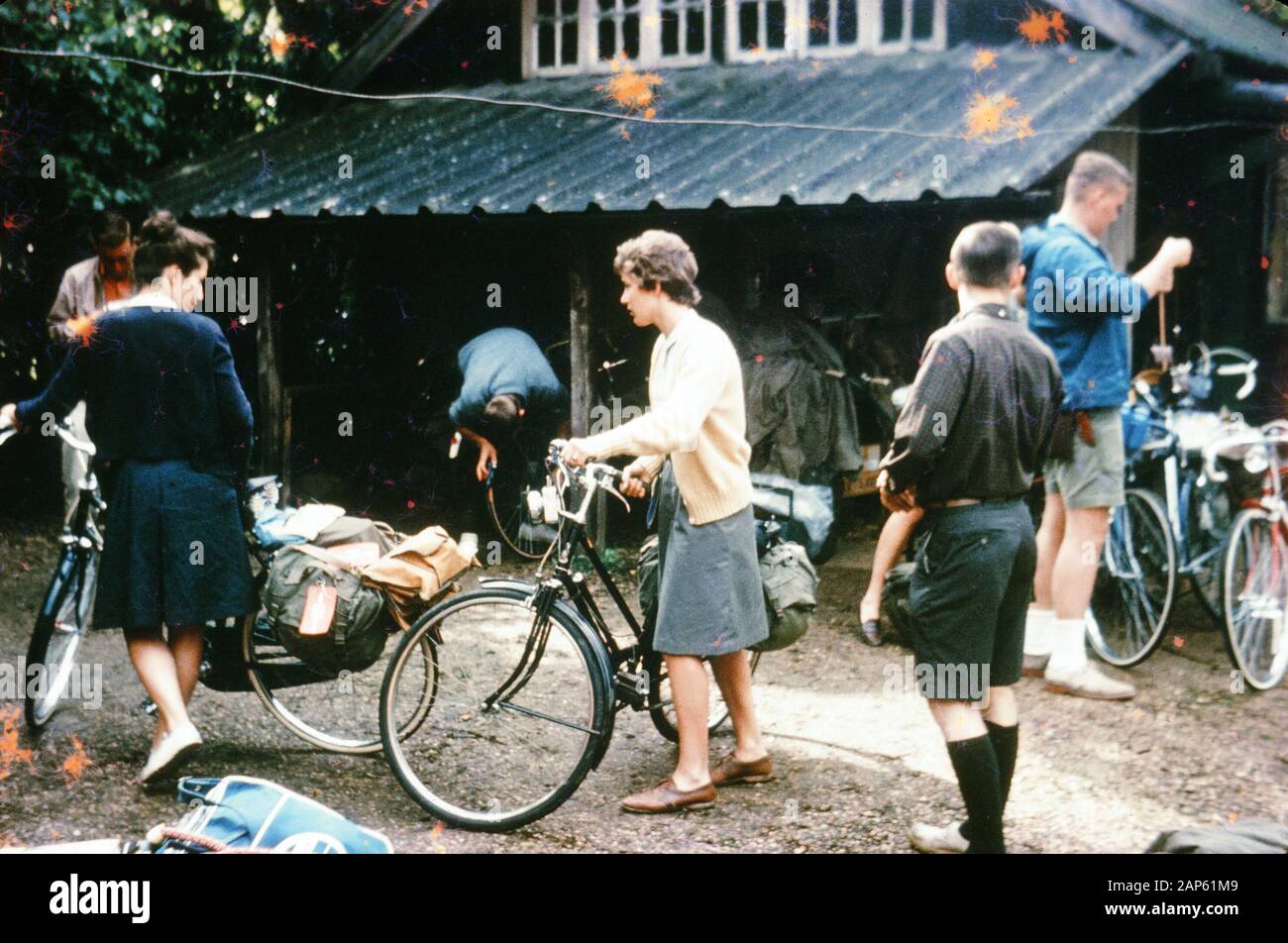 Nakuläres Foto, aufgenommen auf einer analogen 35-mm-Filmtransparenz, glaubte, den Mann in weißem Hemd neben der Frau in grauem Hemd mit Fahrrädern, 1965, darstellen zu können. Zu den wichtigsten Themen/Objekten, die erfasst wurden, gehören Person, Outdoor, Fahrrad, Menschen, Trans Bicycle, Fahrzeug und Gruppe. () Stockfoto
