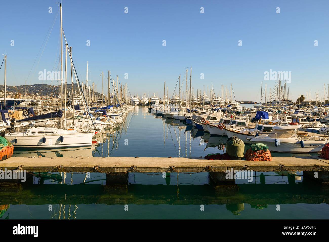 Blick auf den Hafen von Porto Maurizio an der Riviera der Blumen mit gepanzerten Booten und Fischernetzen auf einem Holzwirbelturm, Imperia, Ligurien, Italien Stockfoto