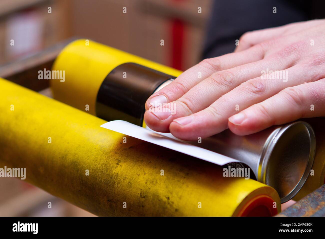 Manuelles Aufkleben von Aufklebern auf Aerosoldosen mit Automobil- und anderer chemischer Zusammensetzung Stockfoto