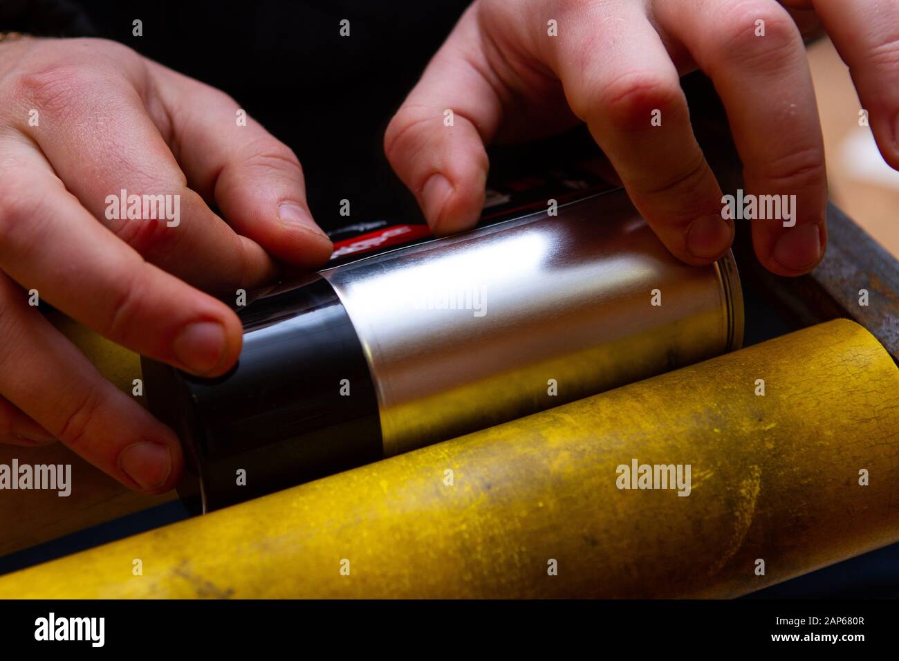 Manuelles Aufkleben von Aufklebern auf Aerosoldosen mit Automobil- und anderer chemischer Zusammensetzung Stockfoto