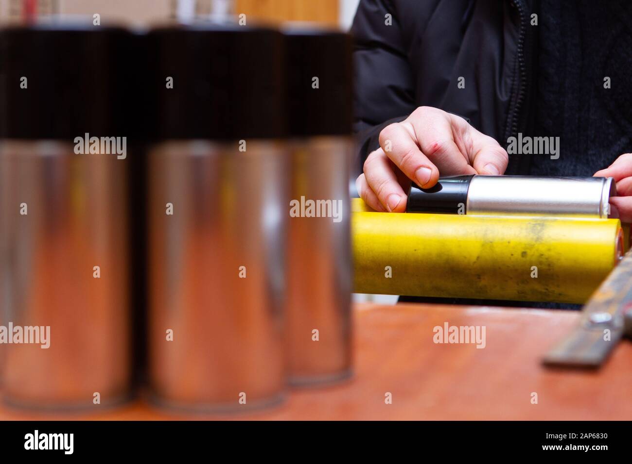 Manuelles Aufkleben von Aufklebern auf Aerosoldosen mit Automobil- und anderer chemischer Zusammensetzung Stockfoto