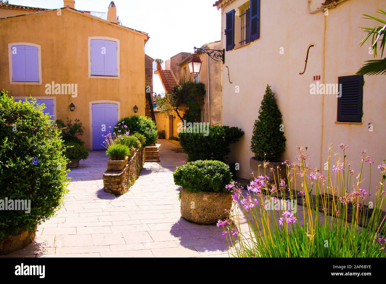 Blick auf den Platz des mediterranen Dorfes mit Blumen- und Grünpflanzen in strahlendem Sonnenschein - Gassin, Cote d'Azur, Frankreich Stockfoto