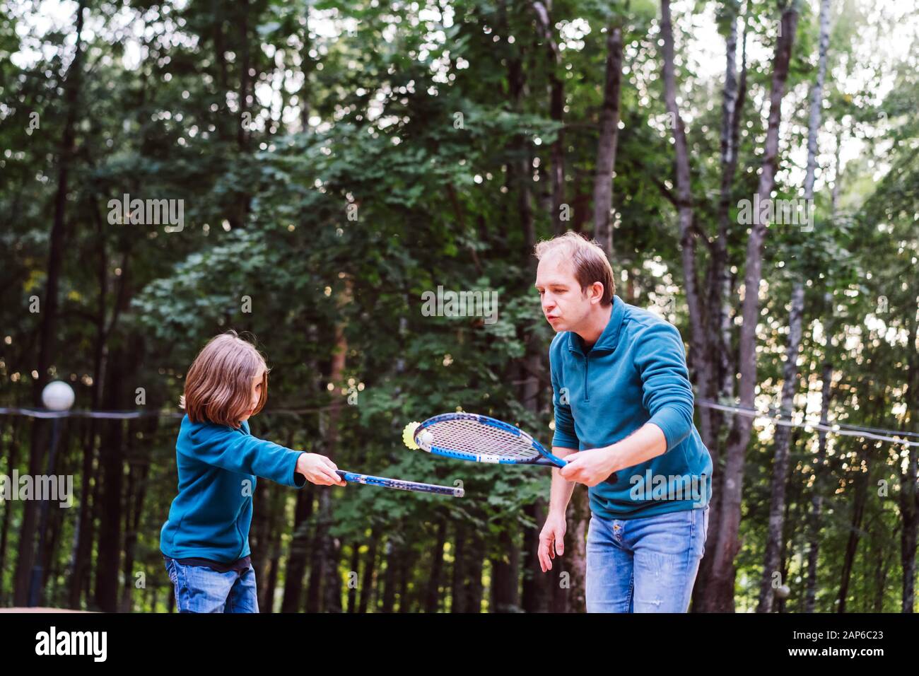 Vater lehrt Sohn Badminton im Park zu spielen. Wochenende für Zwei. Stockfoto