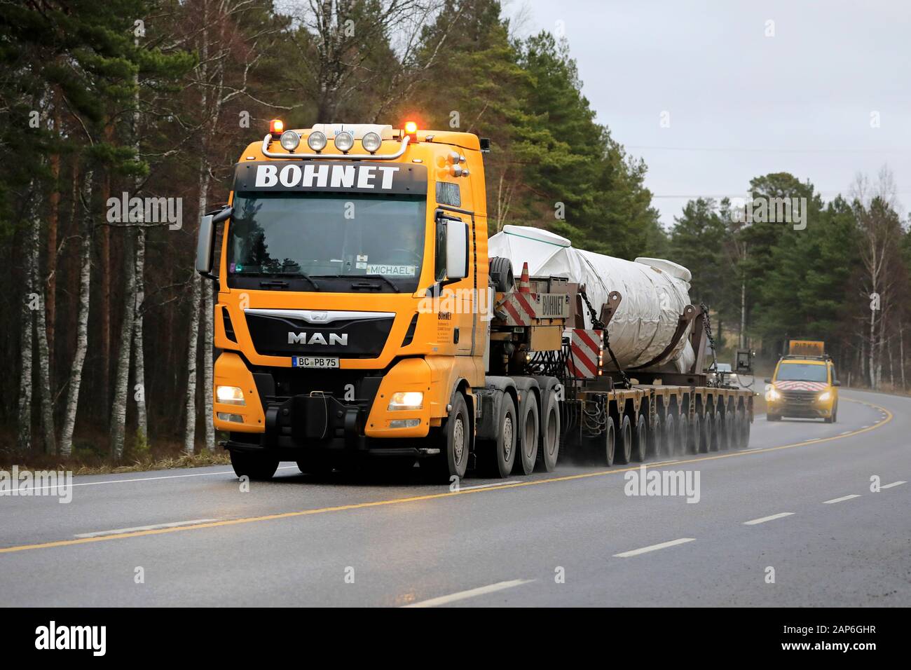 Gelb MAN TGX Bohnet GmbH semi tieflader Hols industrielle Ausrüstung wie übergroße Ladung auf der Straße in Richtung Hafen von Hanko. Raasepori, Finnland. Jan 17, 2020 Stockfoto