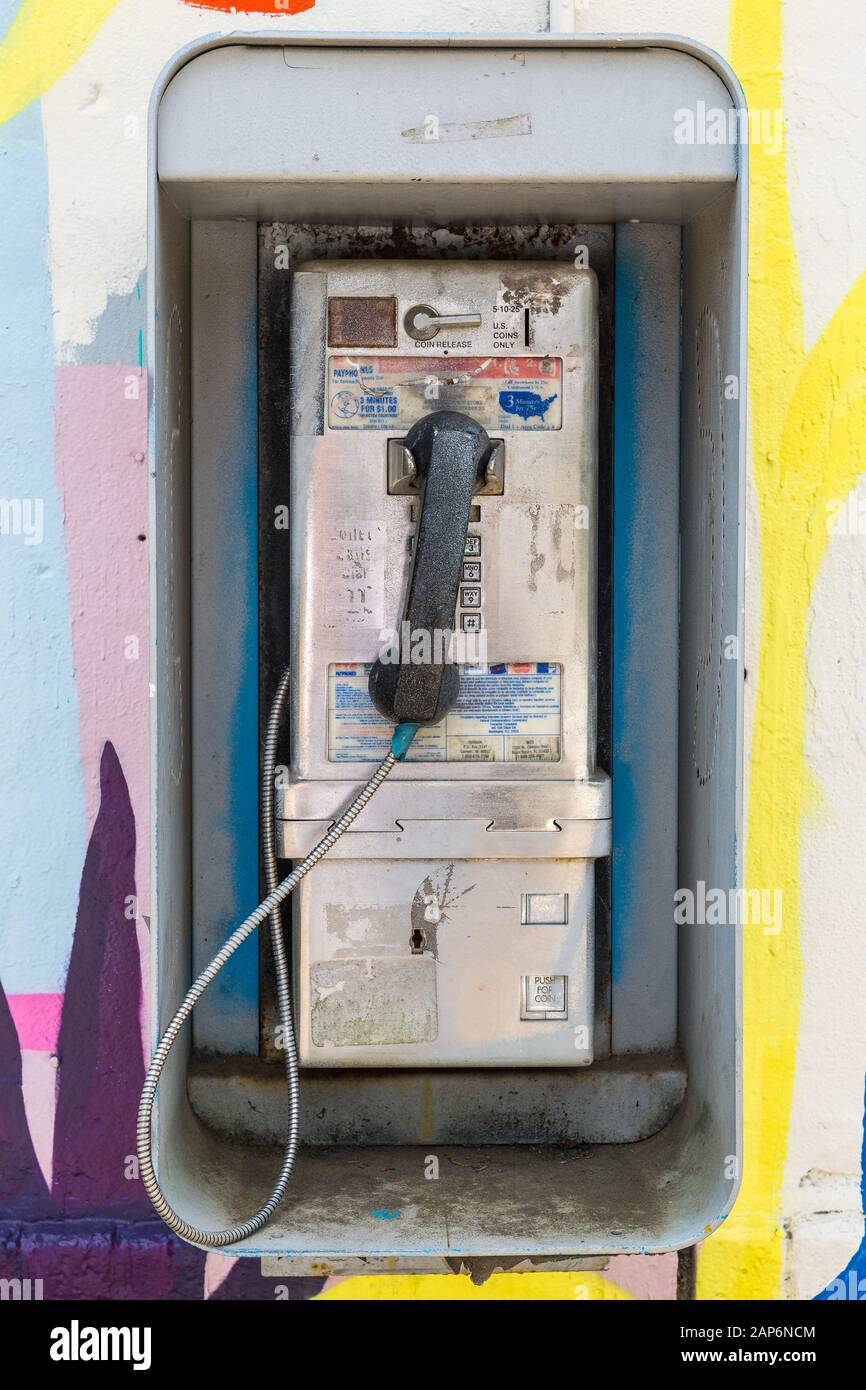 Altes kaputtes Zahltelefon an der Wand Stockfoto