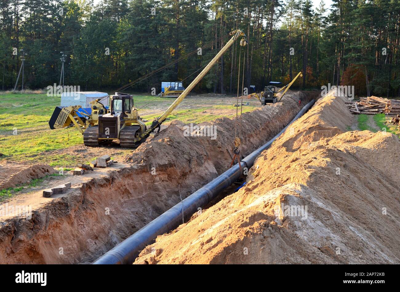 Ein Ausgegrabener Graben im Boden für die Installation und Installation von Industriegas- und Ölrohren. T.Raupenkran mit Seitenausleger oder Rohrbauchbulldoze Stockfoto