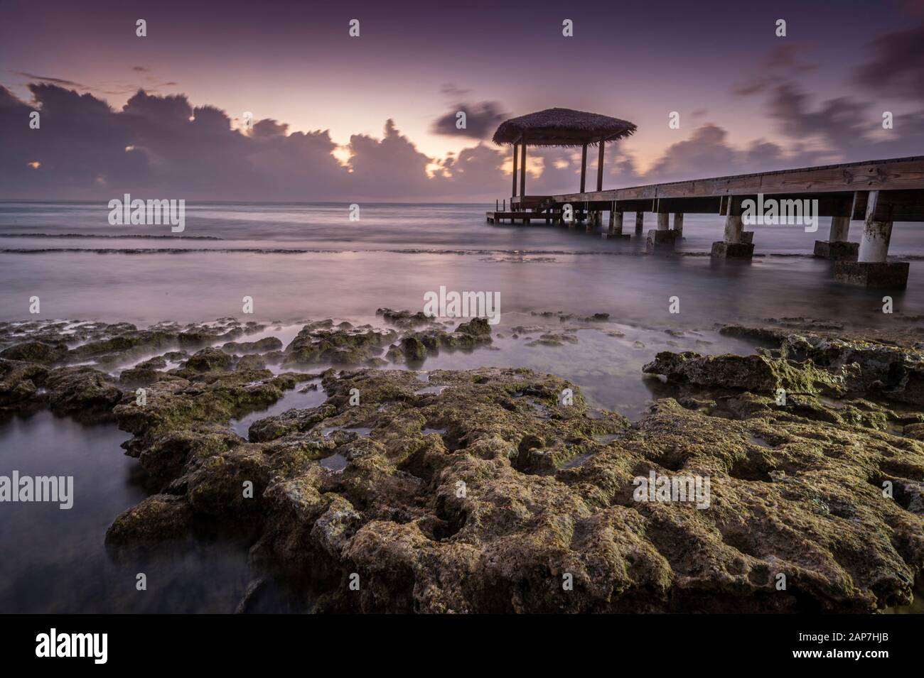 Pavillon am Pier mit nebligen Wellen, die auf felsigem Ufer, Grand Cayman Island, abstürzen Stockfoto