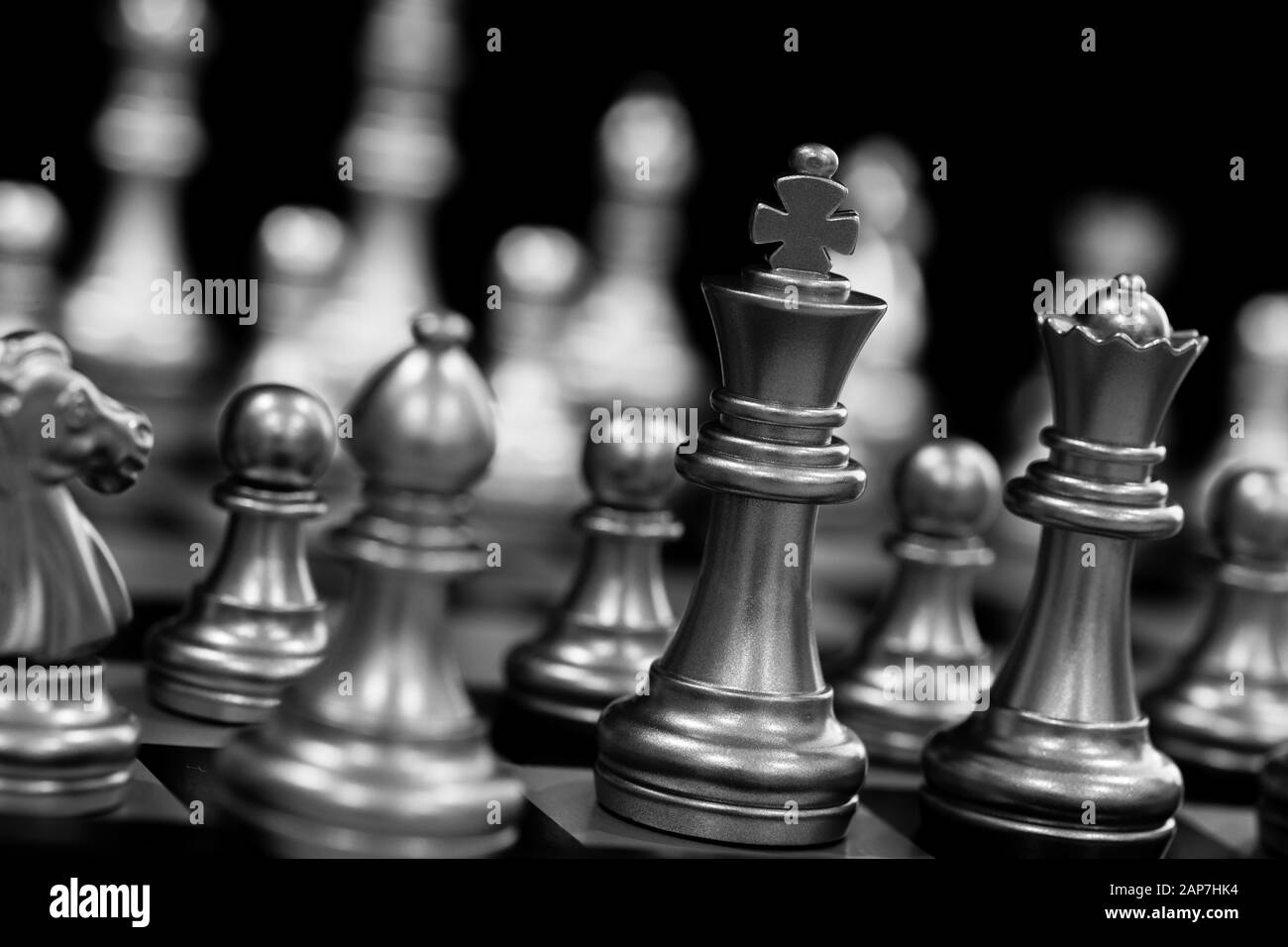 Der König in der Schlacht schach spiel stehen auf Schachbrett mit schwarzem Hintergrund isoliert. Business Leader Konzept für Markt strategie. Intelligenz Cha Stockfoto
