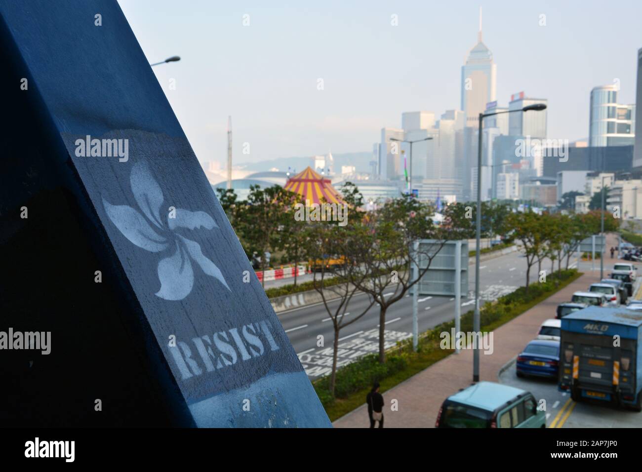 Protestgraffiti auf einer Fußgängerüberführung mit der Skyline im Hintergrund im Central District von Hongkong gemalt. Stockfoto