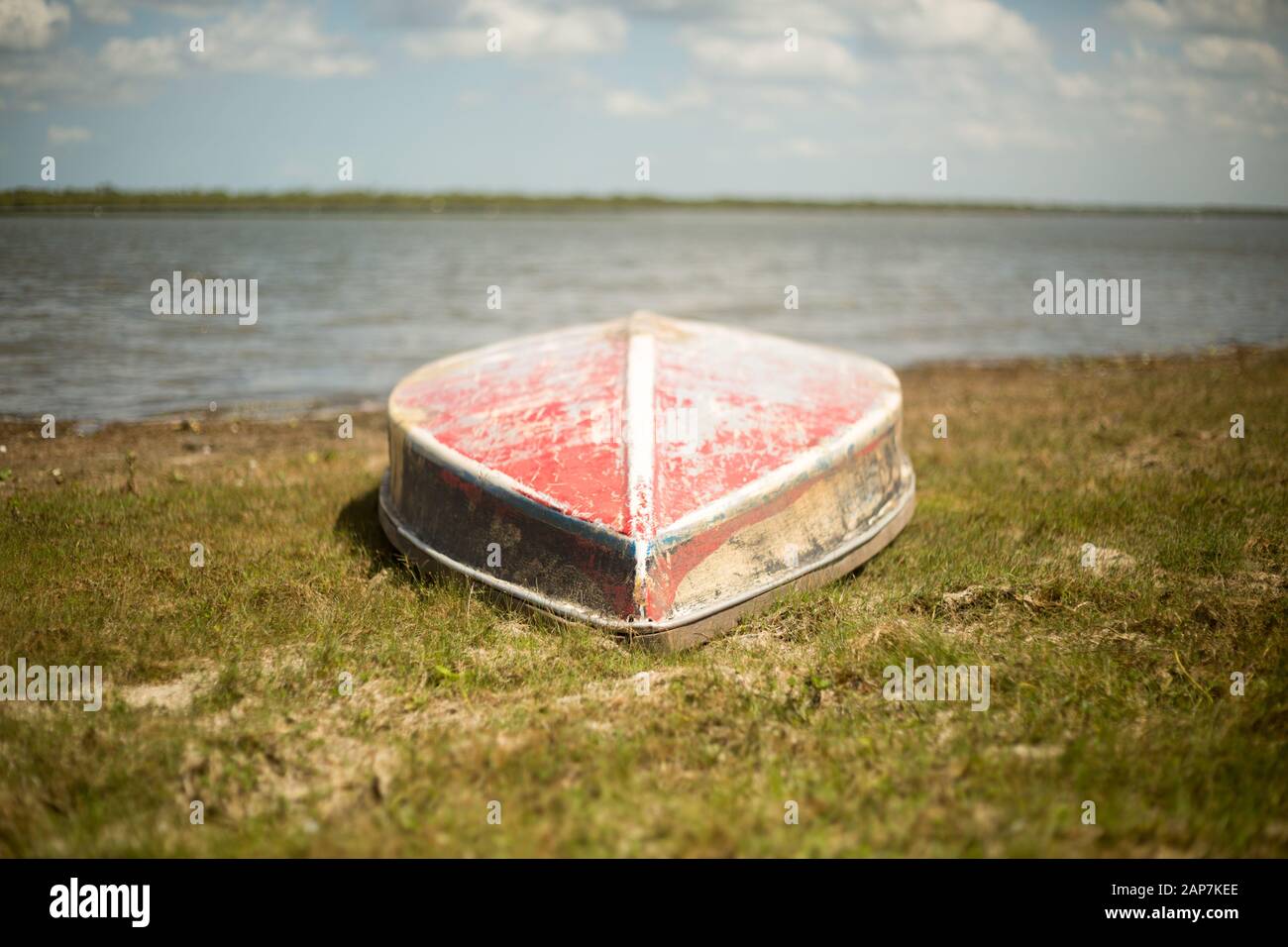 Ein altes buntes Boot ruht auf der Küstenlinie Stockfoto