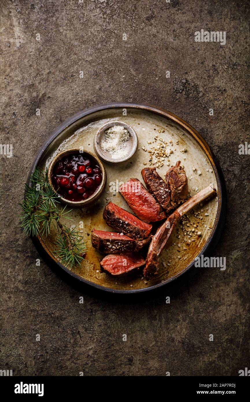 Gegrillte, geschnittene Wildlippen und Beerensauce auf dunklem Hintergrund Stockfoto