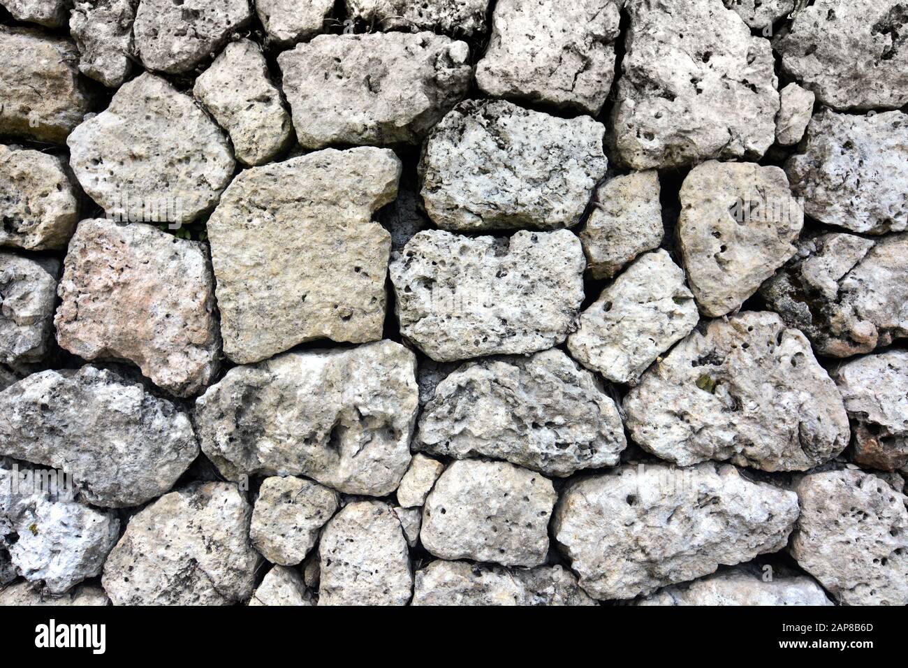 Steinhalterter Wandhintergrund aus lokalen Materialien ohne Mörtel oder Beton Stockfoto