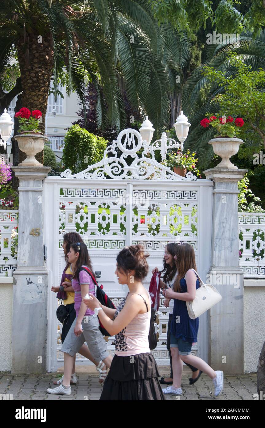 Junge Frauen passieren die Tore eines wali- oder Sommerhauses der ottomanischen Zeit auf Buyukada, Prinzeninseln, Istanbul Stockfoto