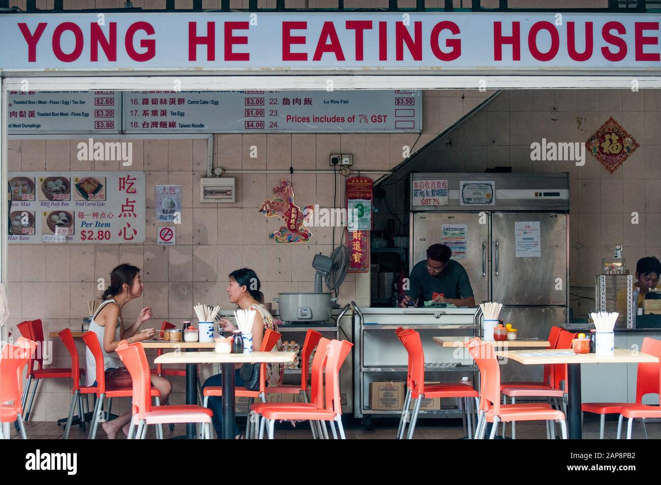 Zwei Freundinnen speisen in einem Café in der Geylang Road, Singapur Stockfoto