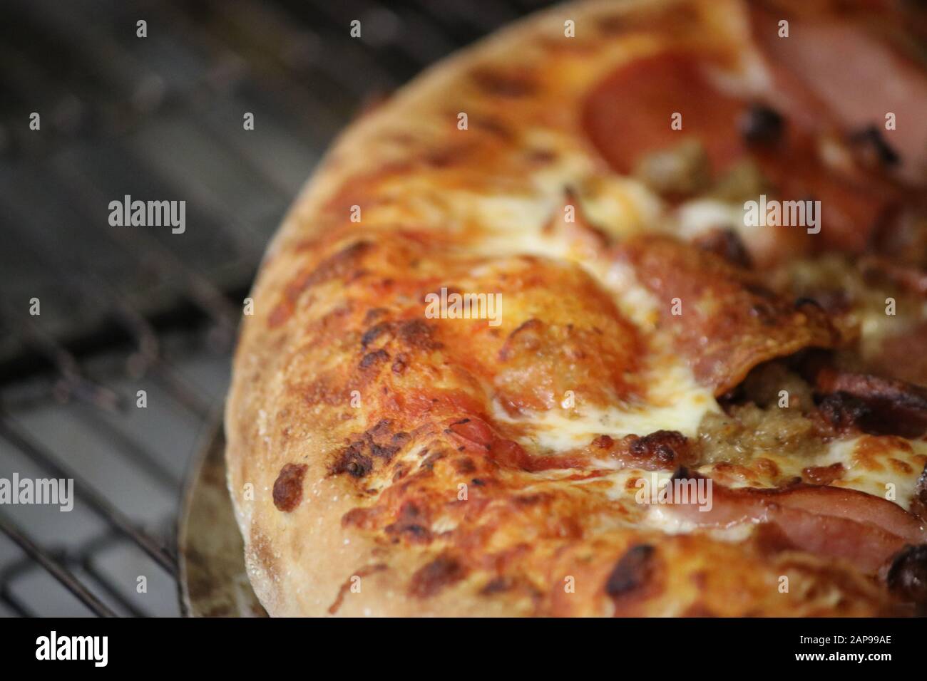 Frisch gebackene italienische Pizza, Pfefferoni, Pilze, Wursttopflecken, Pizzasauce, Mozzarella-Käse, Mitnahme oder Pizza-Lieferung im Pizza-Restaurant Stockfoto