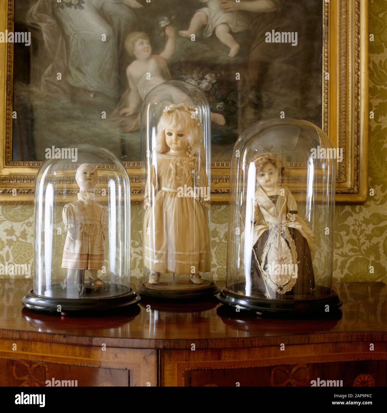Nahansicht von drei Puppen des achtzehnten/neunzehnten Jahrhunderts in Glas-Vitrinen auf der Landungsfläche des State Bedroom am Clevedon Court. Stockfoto