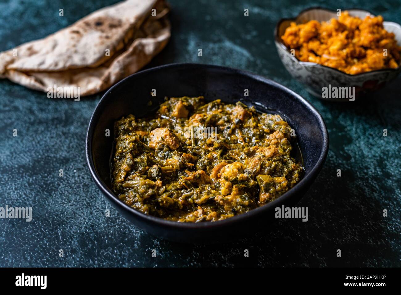 Das indische Gericht Spinach Lamb Palak mit Gajar ka Halwa/Helva ist ein süßer Dessertpudding auf Karottenbasis aus Indien und Flat Bread Chappati. Bereit zum Servieren. Stockfoto