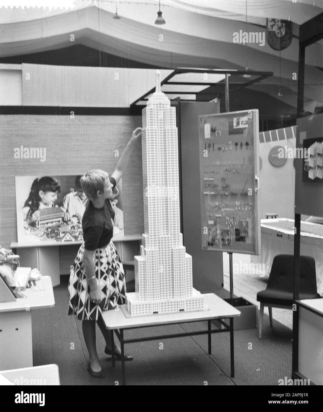 Frauenmesse in Houtrusthallen. Mädchen mit modelem Wolkenkratzer Datum: 28. September 1961 Schlagwörter: Frauenmessen, Mädchen, Wolkenkratzer Institutionenname: Holztrussen Stockfoto