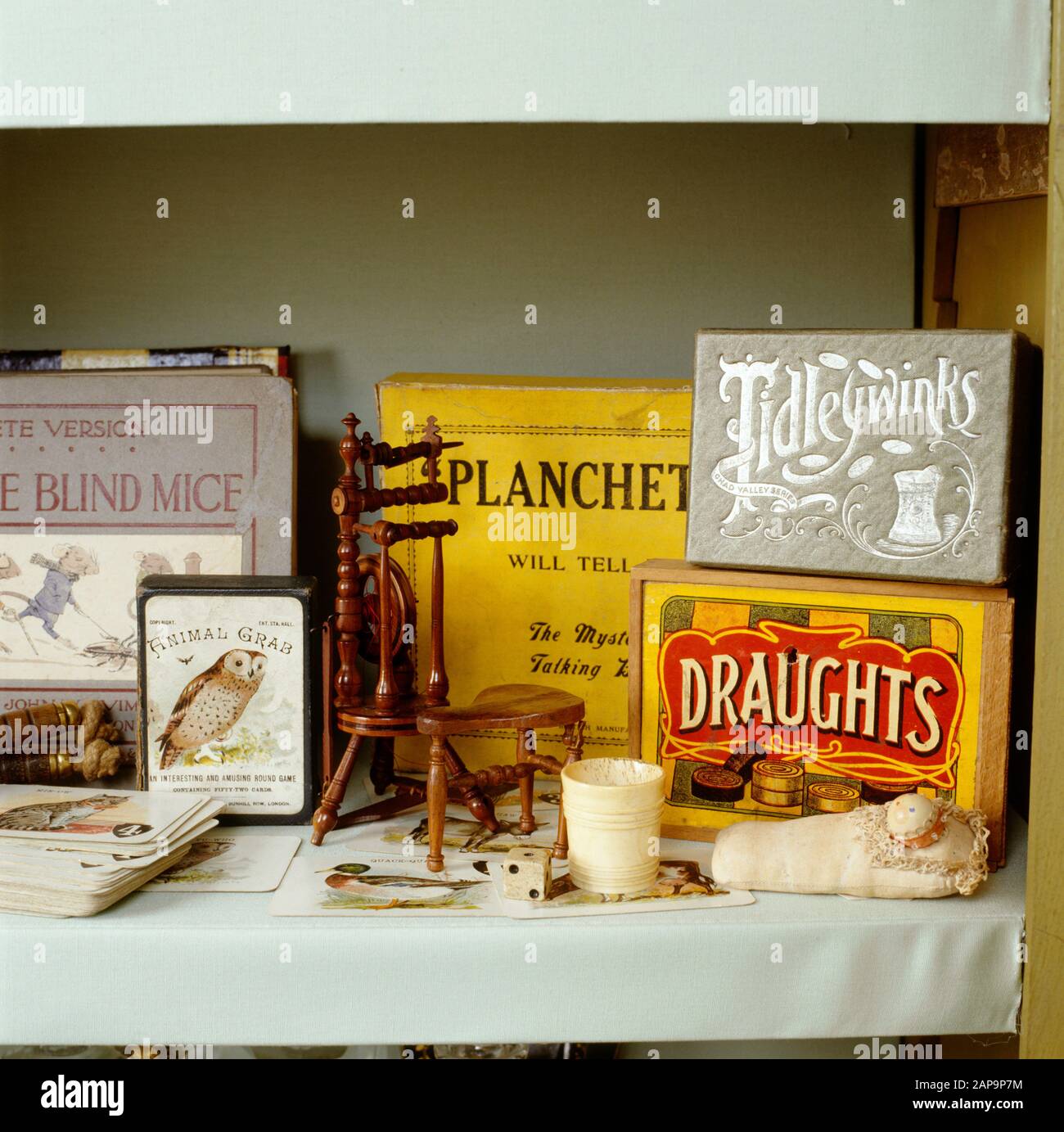 Details zur P.M.Ward Kollektion von Spielzeug und Spielen in einem Vitrine umfasst Entwürfe, Tidleywinks, Planchette, Spielkarten, eine Miniaturdrehung Stockfoto