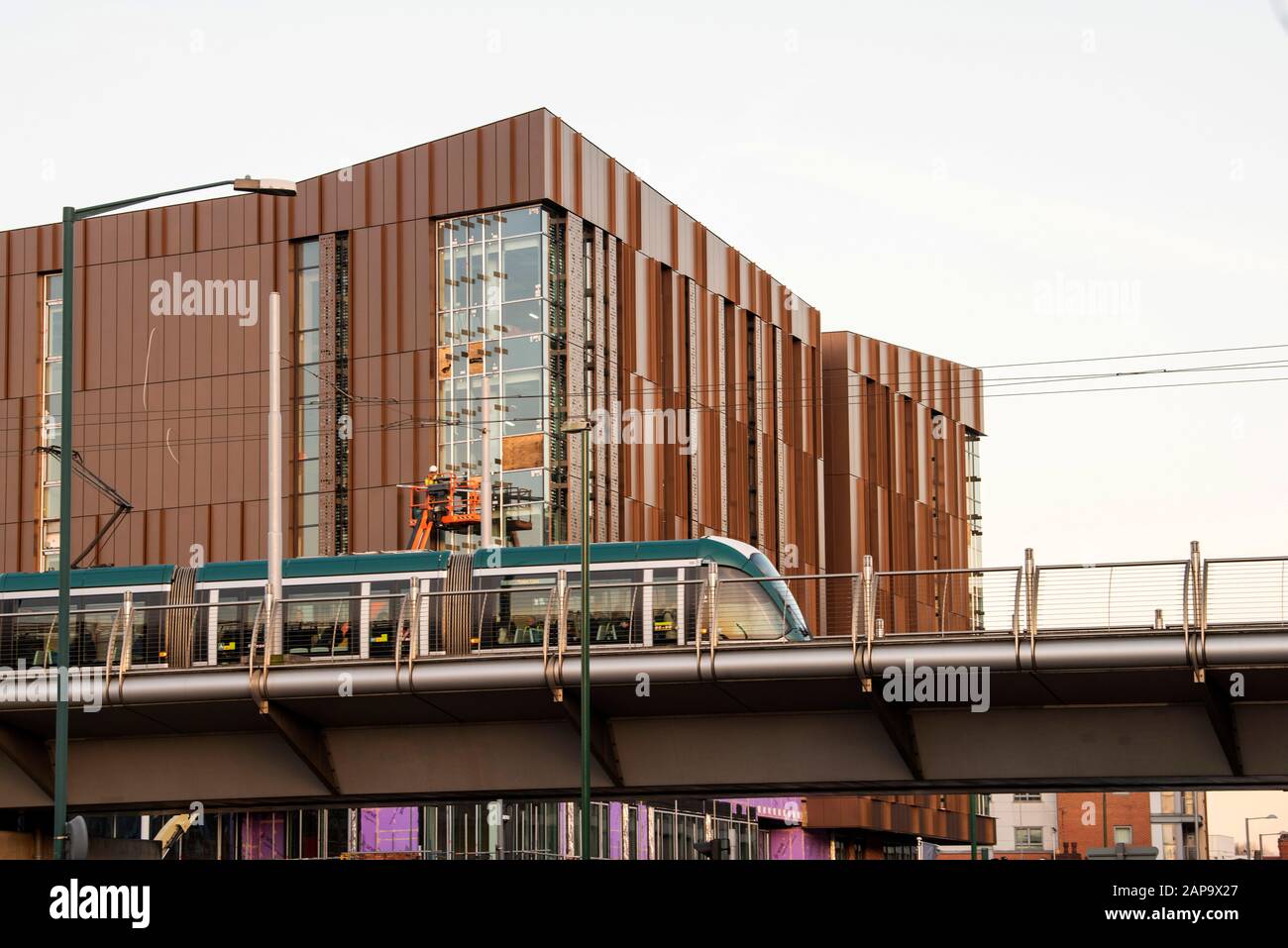 Eine Straßenbahn, die am neuen Nottingham College City Hub in Nottingham City South Side, Nottinghamshire England UK, vorbeiführt Stockfoto