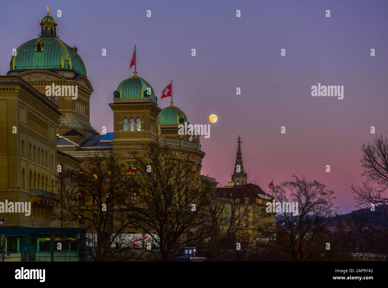 Bundeshaus in der Abenddämmerung mit Schweizer Flagge und Mond, Bern, Schweiz Stockfoto