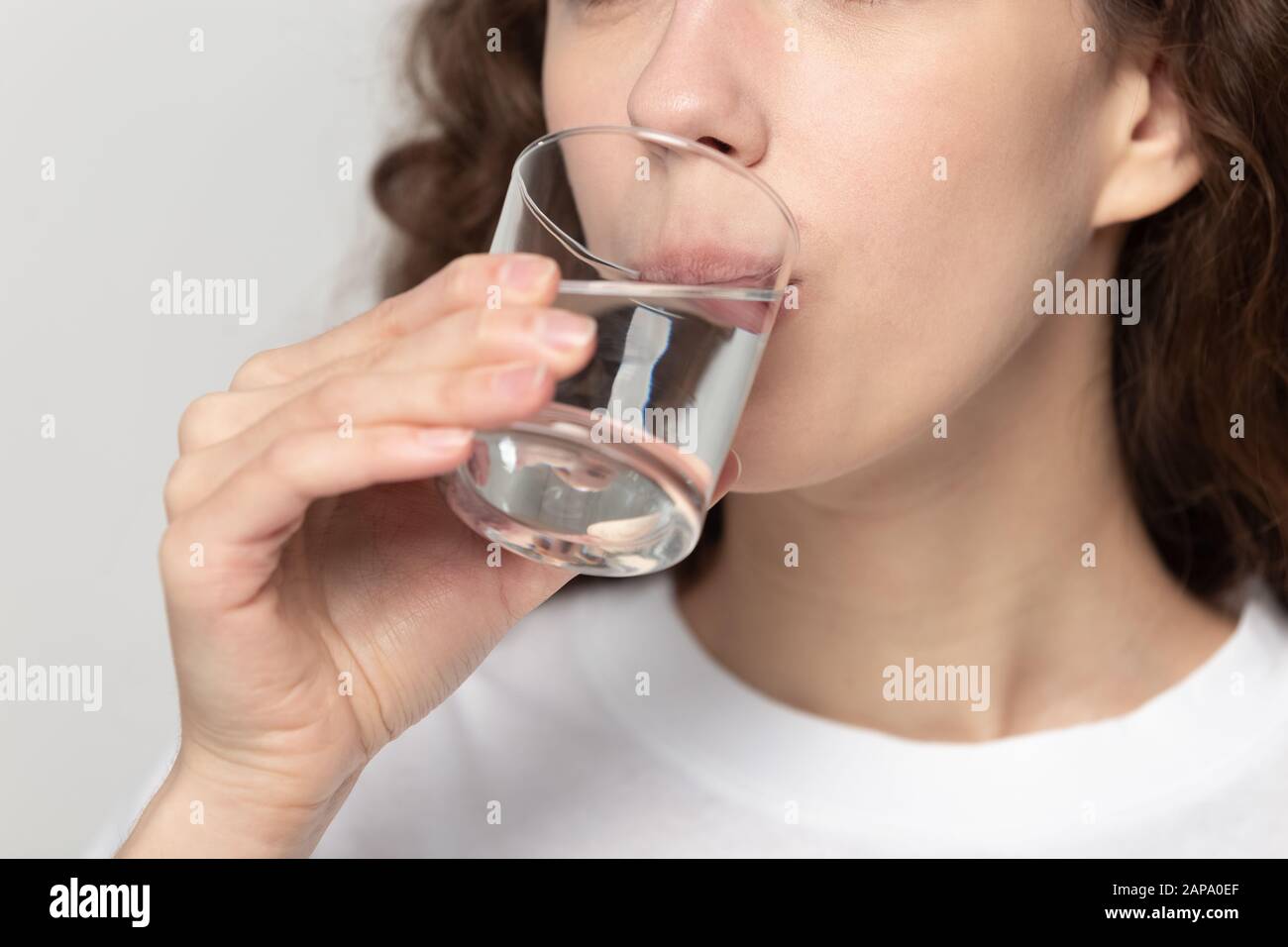Schließen Sie junge gesunde Frau, die Glas Wasser trinkt. Stockfoto