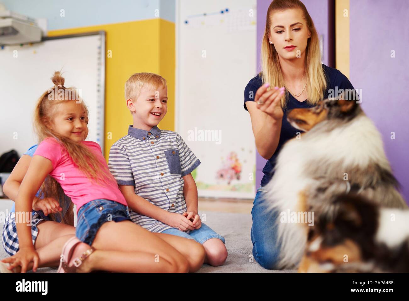 Glückliche Kinder mit Hund während der Therapie Stockfoto