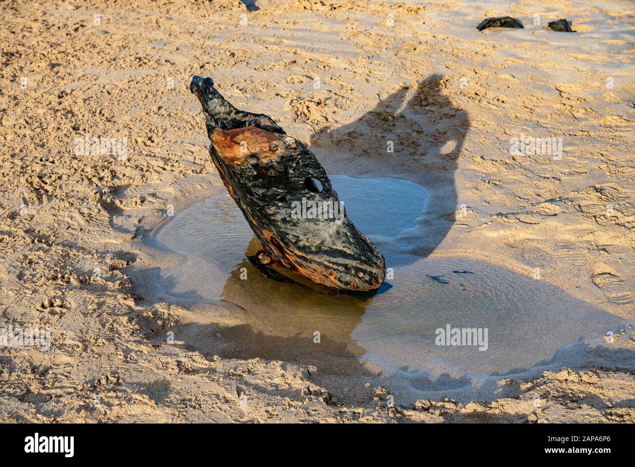 Ein Metallstück aus einem Schiffswrack bildet mit dem Schatten Constantine Bay Beach North Cornish Coast, Großbritannien, abstrakte Form Stockfoto