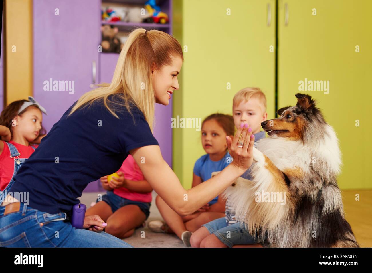 Therapiehund schenkt Frau die Pfote Stockfoto