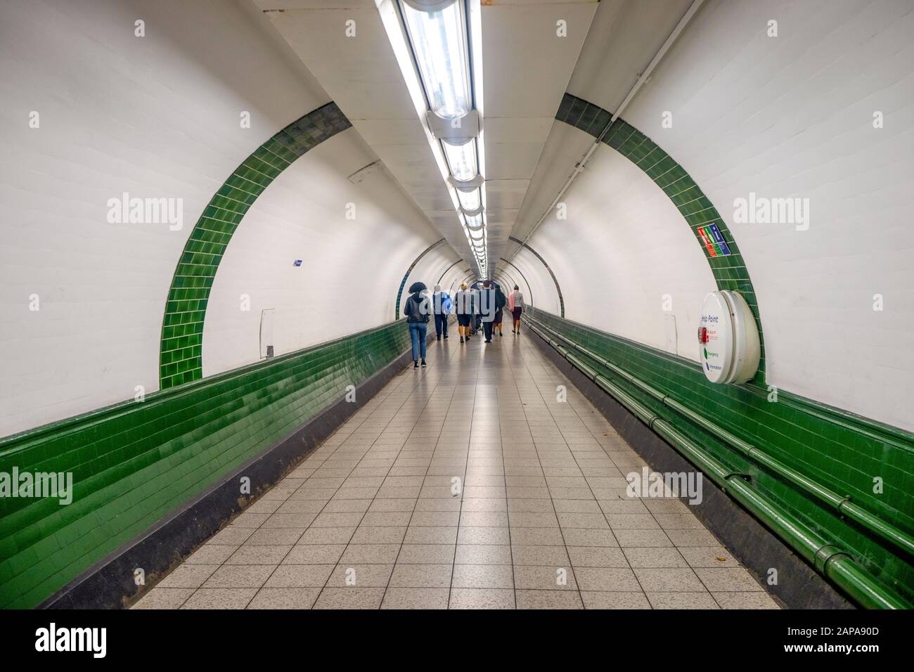 Einige Pendler im weißen Tunnel der U-Bahn-Station in London, Großbritannien Stockfoto