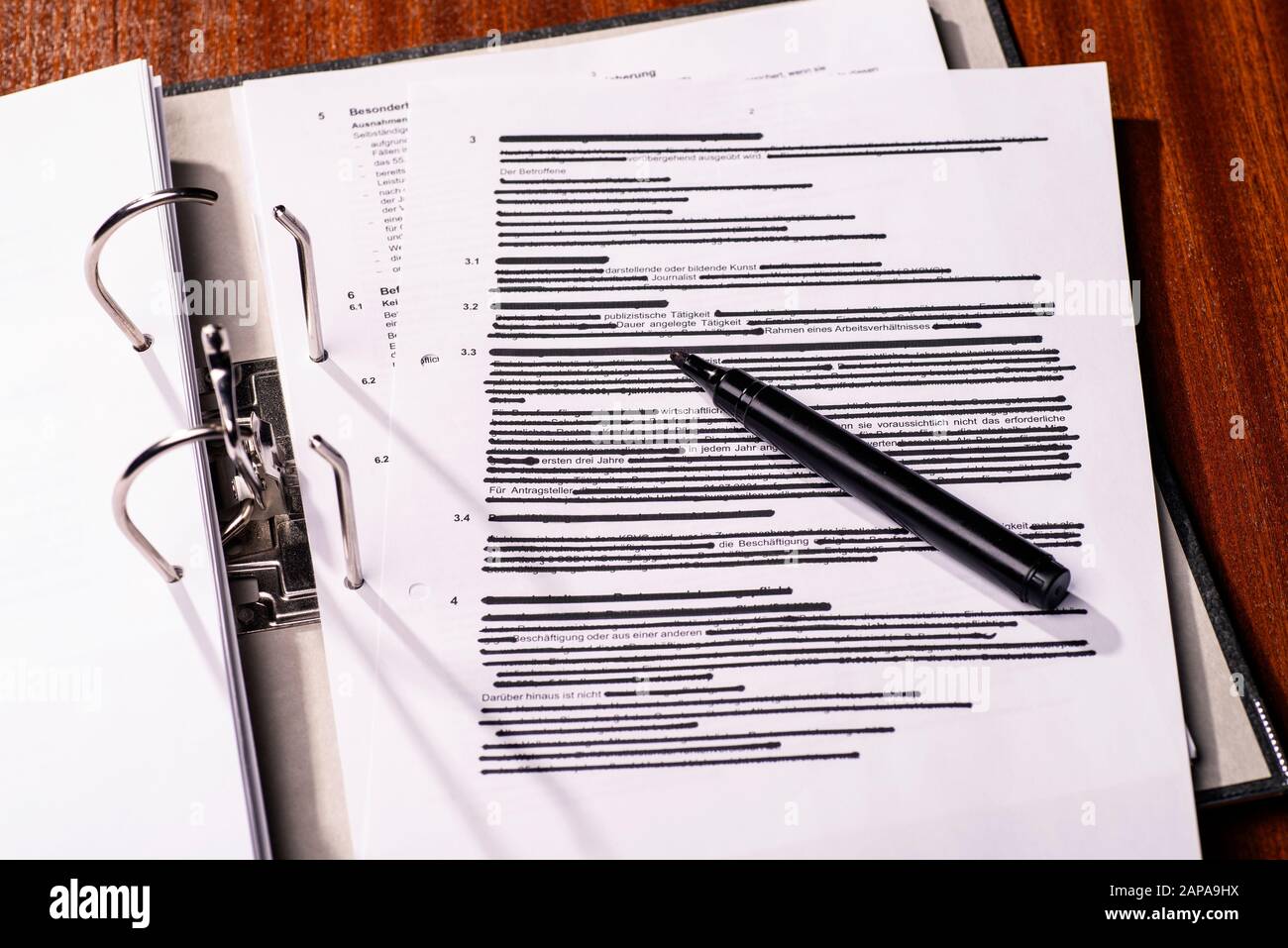 Geöffneter Dateiordner mit überwiegend geschwärzter Seite Stockfoto