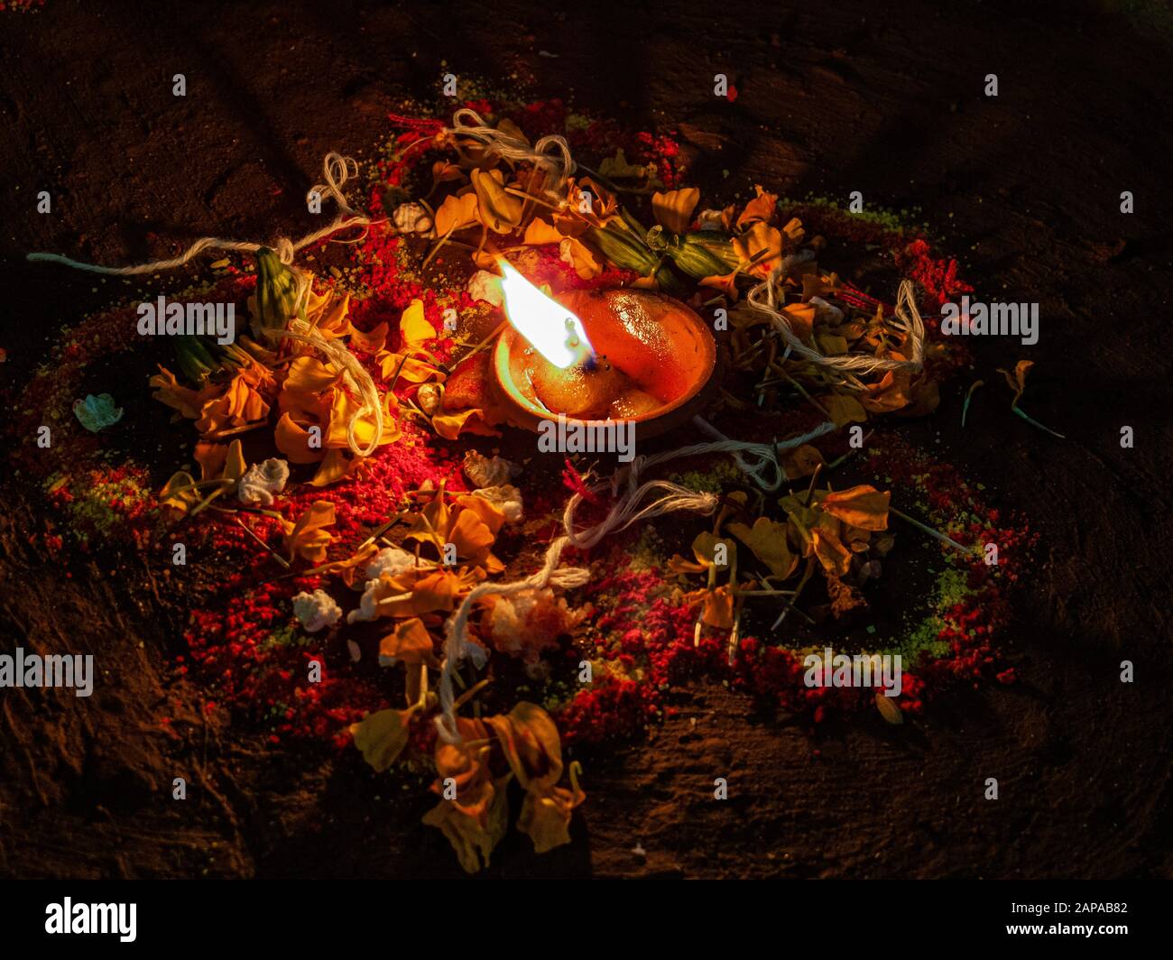 Eine Frau schafft auf dem Boden beim Festival Tihar einen Rangoli mit farbigem Reis, trockenem Mehl und Blumenblättern Stockfoto
