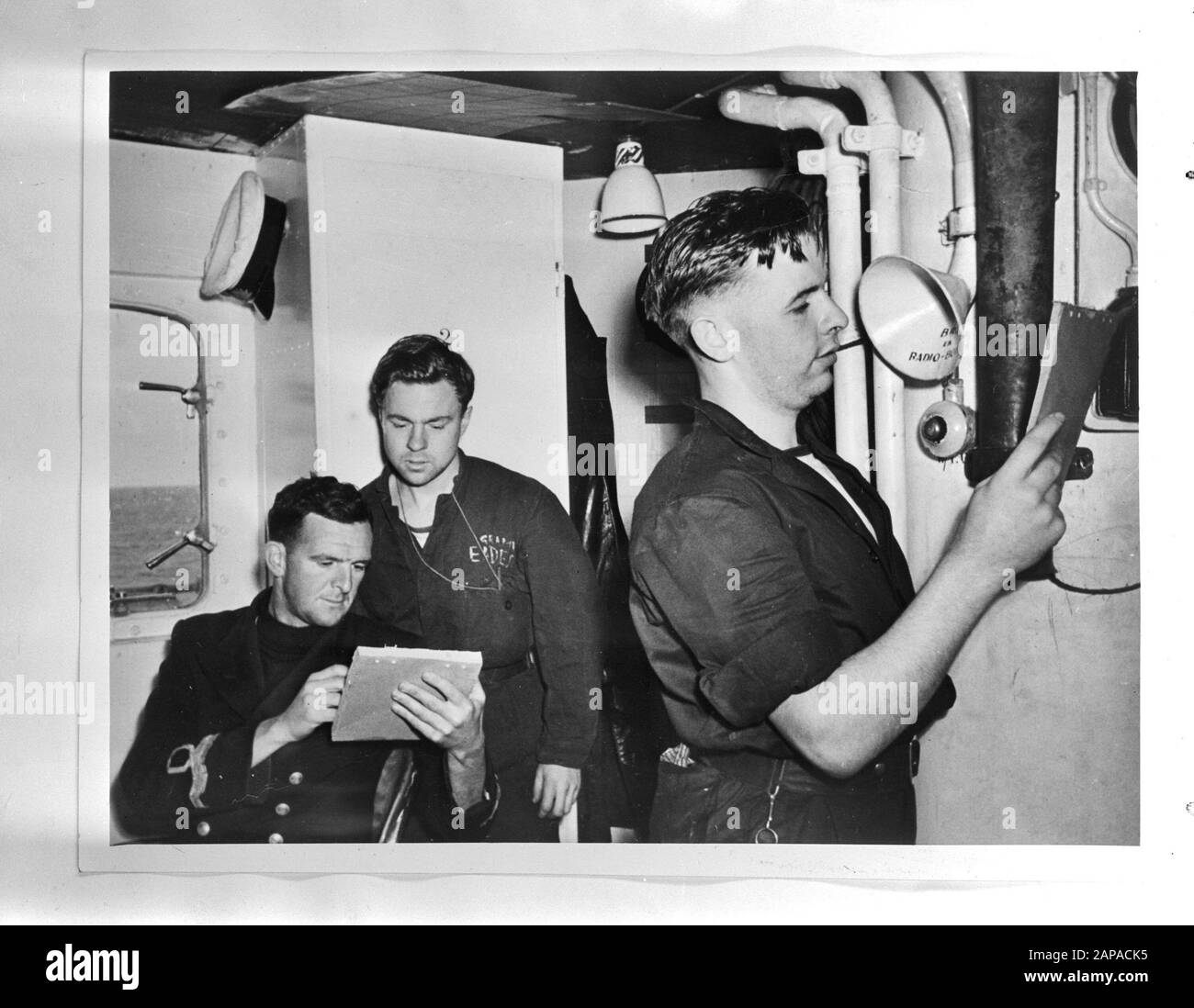 Marine [Navy] Anefo London Serie Beschreibung: An Bord eines holländischen Kreuzers im Südwesten des Pazifischen Ozeans. Leutnant C.K. Griffiths, RANVR, der britische Verbindungsoffizier an Bord (links) in Gesellschaft zweier Signalgeber aus seinem Stab in der Signalkabine. Anmerkung: RANVR = Royal Australian Naval Volunteer Reserve Datum: {1940-1945} Schlüsselwörter: Navy, Offiziere, Kriegsschiffe, World war II persönlicher Name: Griffiths, C.K. Stockfoto