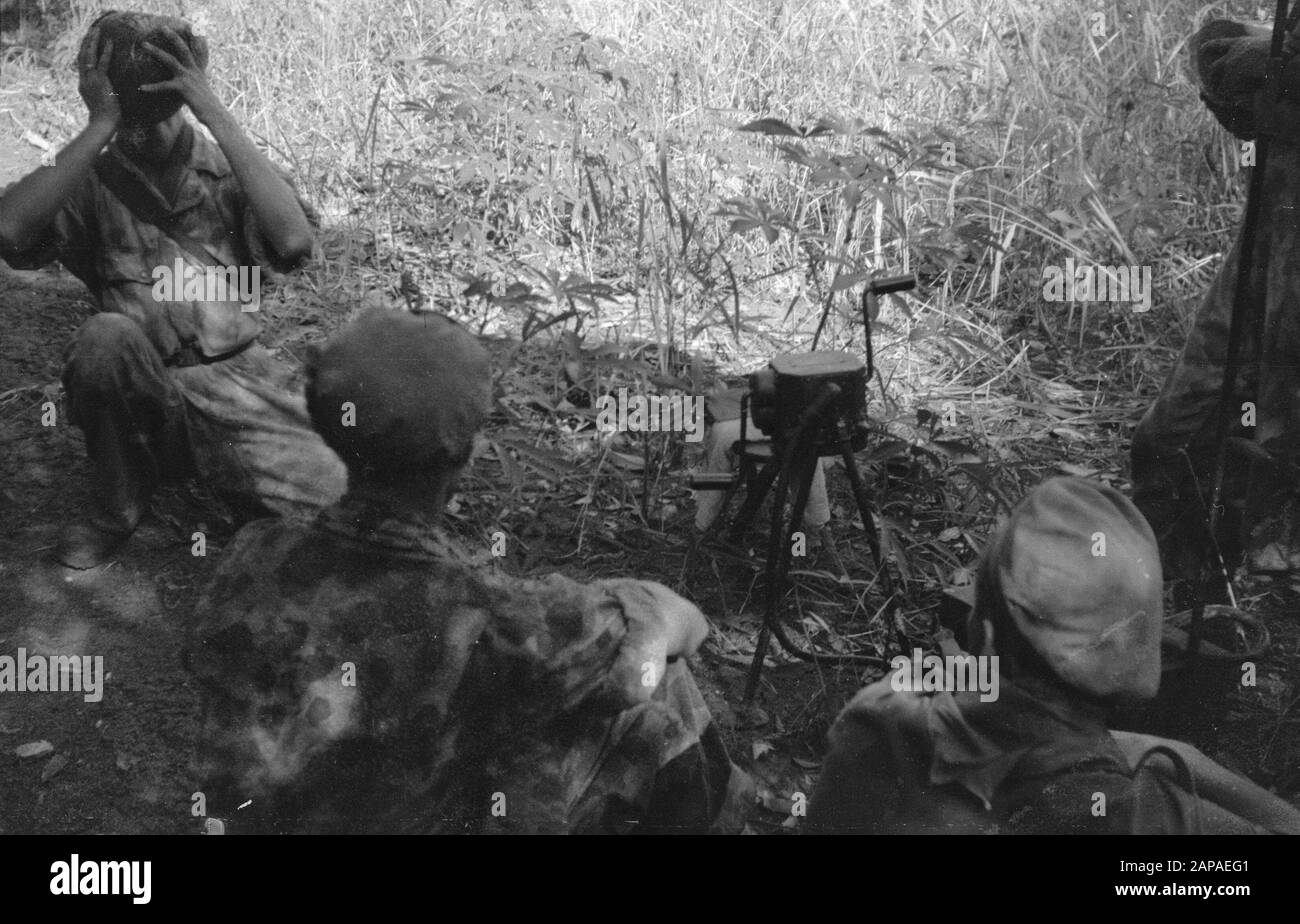Gading und Plajen, Action auf dem Berggelände Beschreibung: Action in Richtung Gading, Plajen und Wonosari. Die Infanterie marschierte nachts, um das Gebiet zu schließen, in dem Banden signalisiert worden waren, als die Säuberungen am Morgen begannen. Ein Soldat trinkt Flap Milk während eines Pausendatums: 9. März 1949 Ort: Indonesien, Java, Niederländische Ostindien Stockfoto