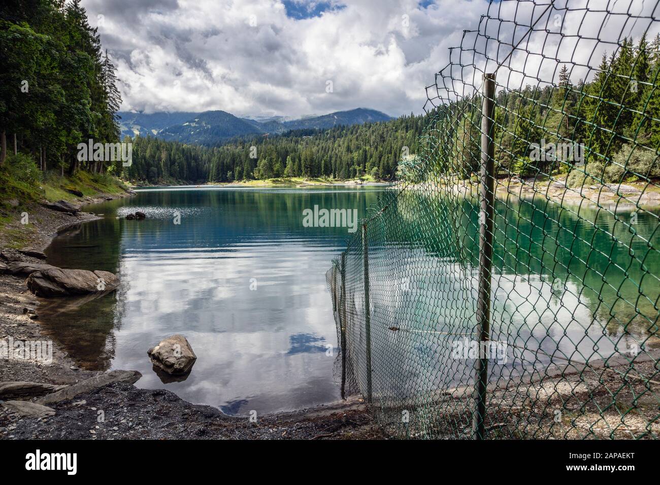 Zaun, der die öffentlichen und privaten Bereiche am Caumasee, Flims, Schweiz, teilt Stockfoto