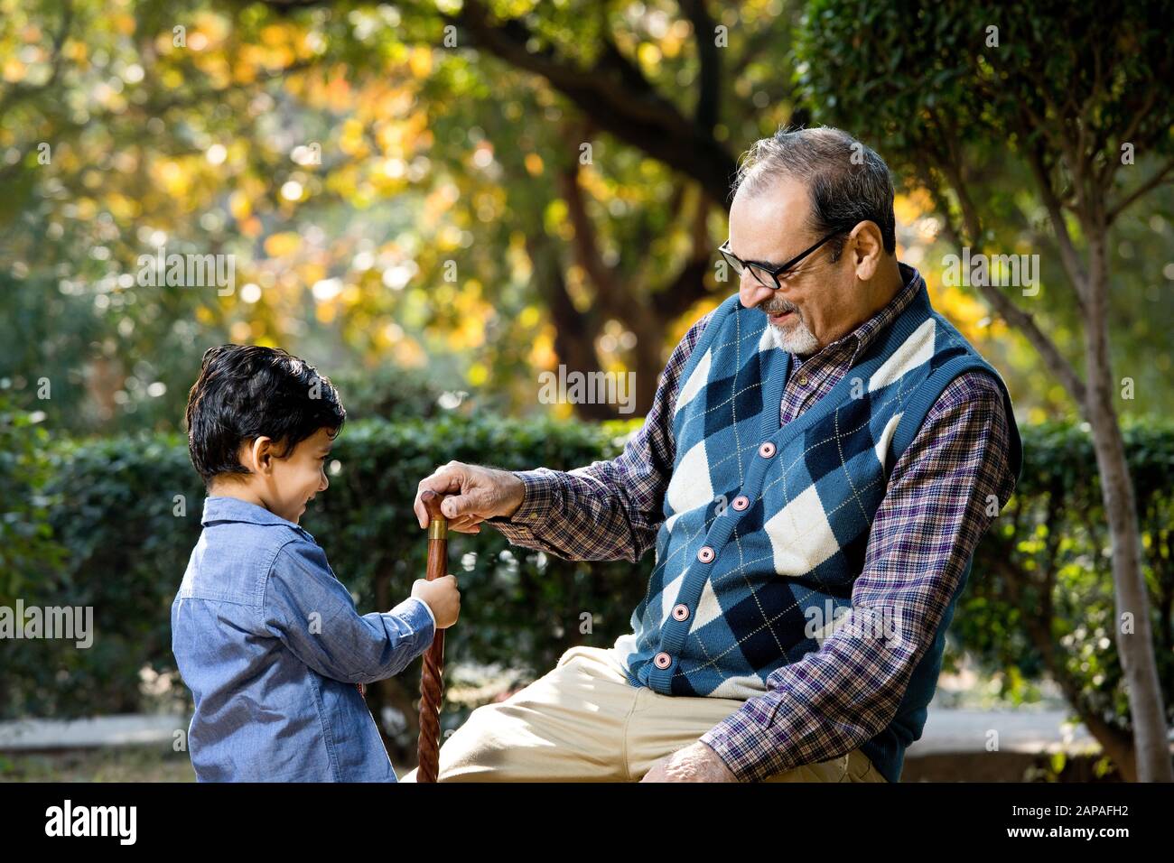 Liebevoller Großvater, der mit seinem Enkel im Park spielt Stockfoto