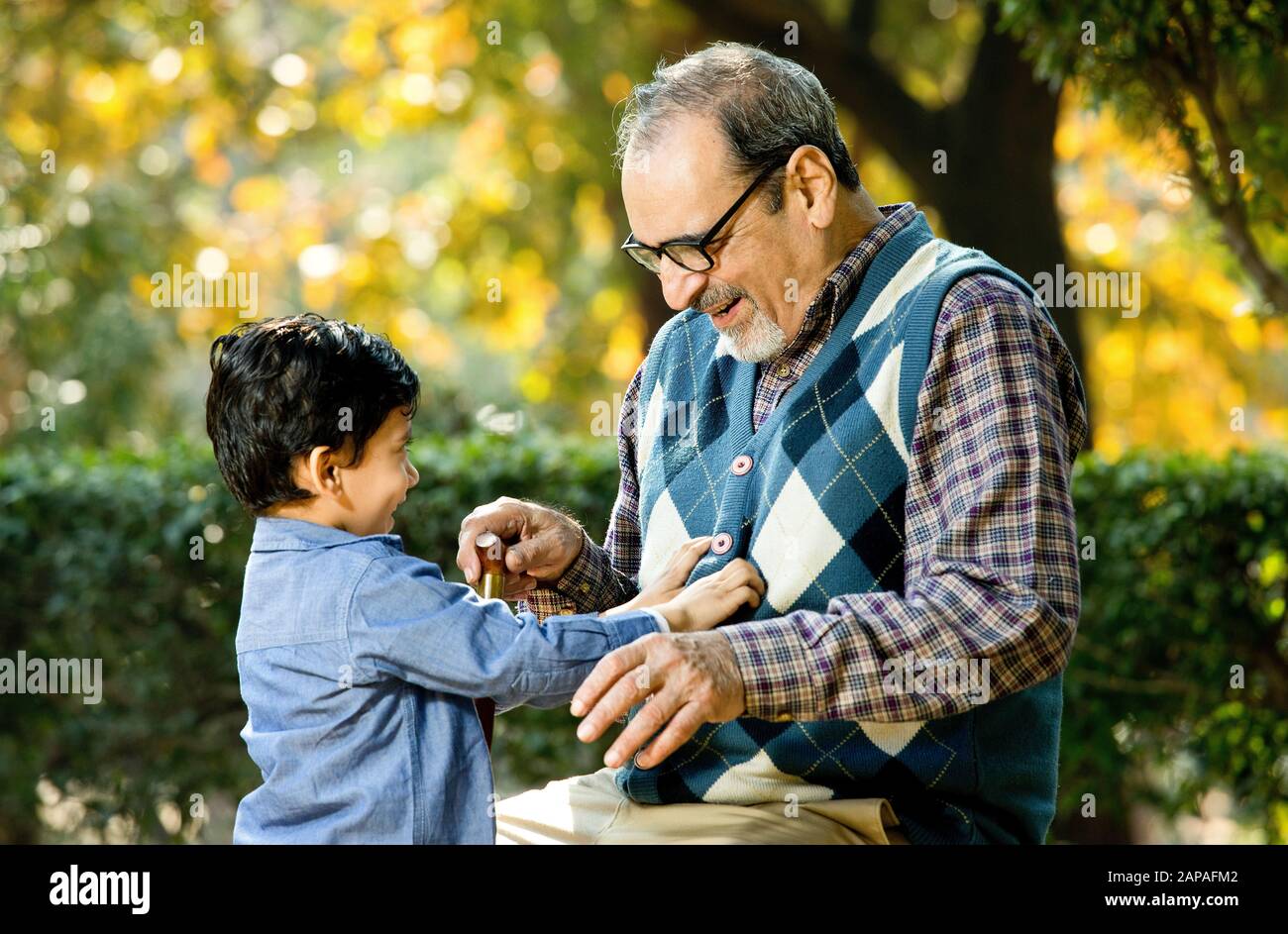 Liebevoller Großvater, der mit seinem Enkel im Park spielt Stockfoto