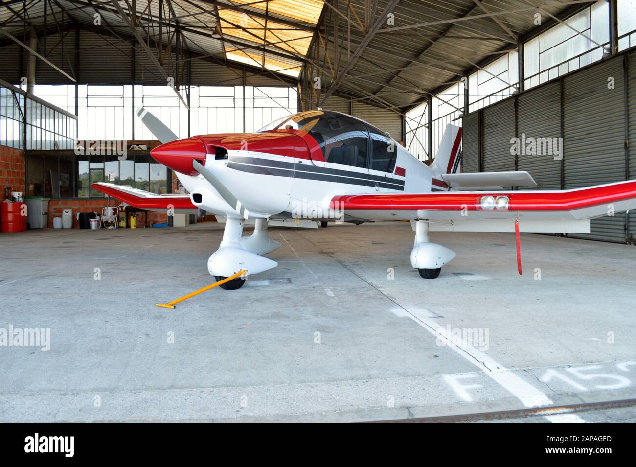 Ein kleines Flugzeug, im Hangarflugzeug auf einem Flughafen geparkt. Stockfoto