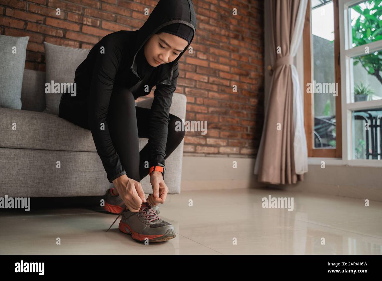 Junge muslimische Frauen in asien tragen Sporthijabs und fixieren  Schnürsenkel vor der Tür Stockfotografie - Alamy